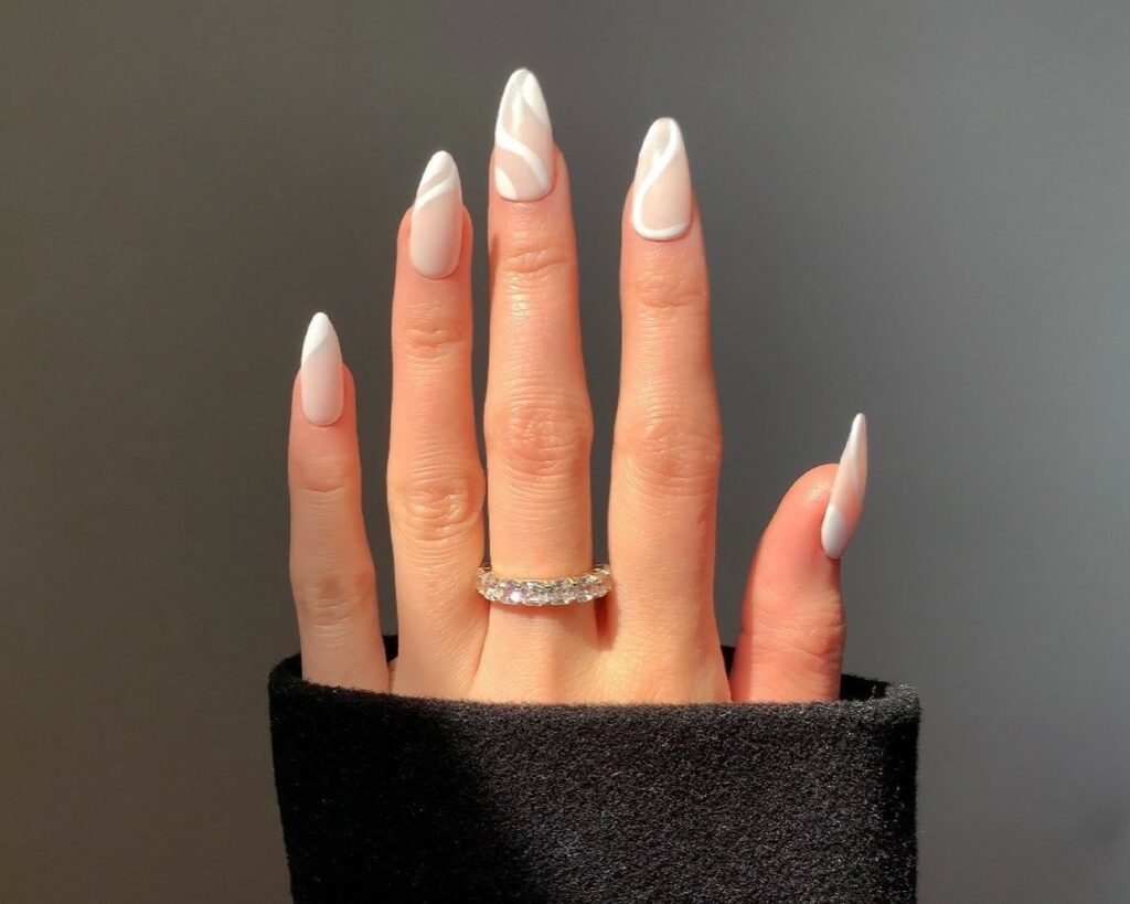 28 Latest Nude And White Nail Designs To Try in 2024! 15 Nude And White Almond Nails With Swirls