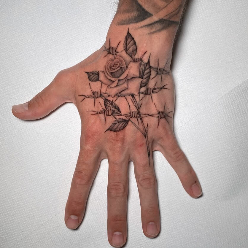 12+ Rose With Thorns Tattoo Ideas To Inspire You! 17 Rose With Thorns X Barbed Wire Hand Tattoo