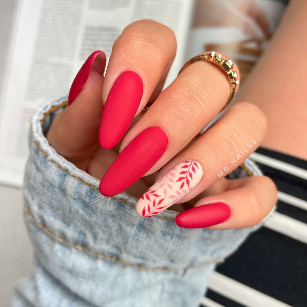 30 Latest Matte Nail Ideas To Try In 2024! 15 Red Matte Almond Accent Nails With Botanical Design