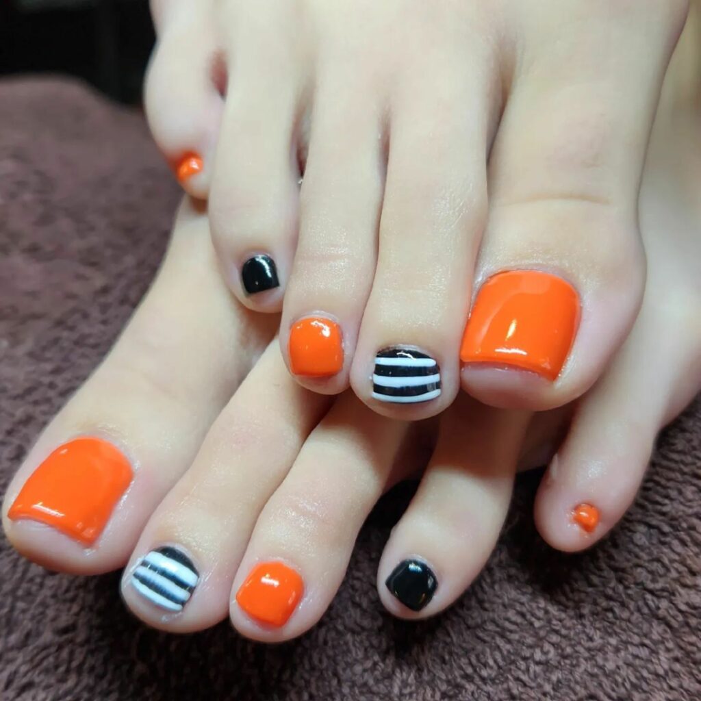30 Spooky Halloween Pedicure Ideas to Try in 2024 24 Striped Sophistication with a Sparkling Touch