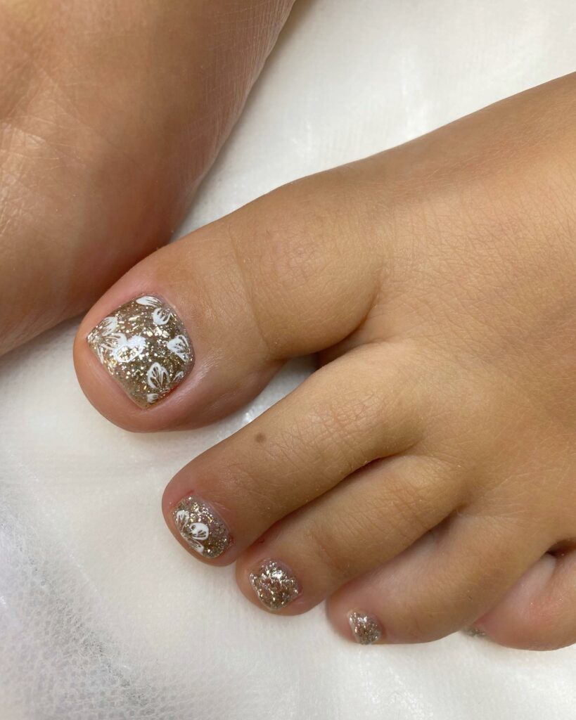 Add Sparkle with 25 Sparkly Toe Nails for 2024 14 Sparkly Nail With Golden Glitters And White Flower