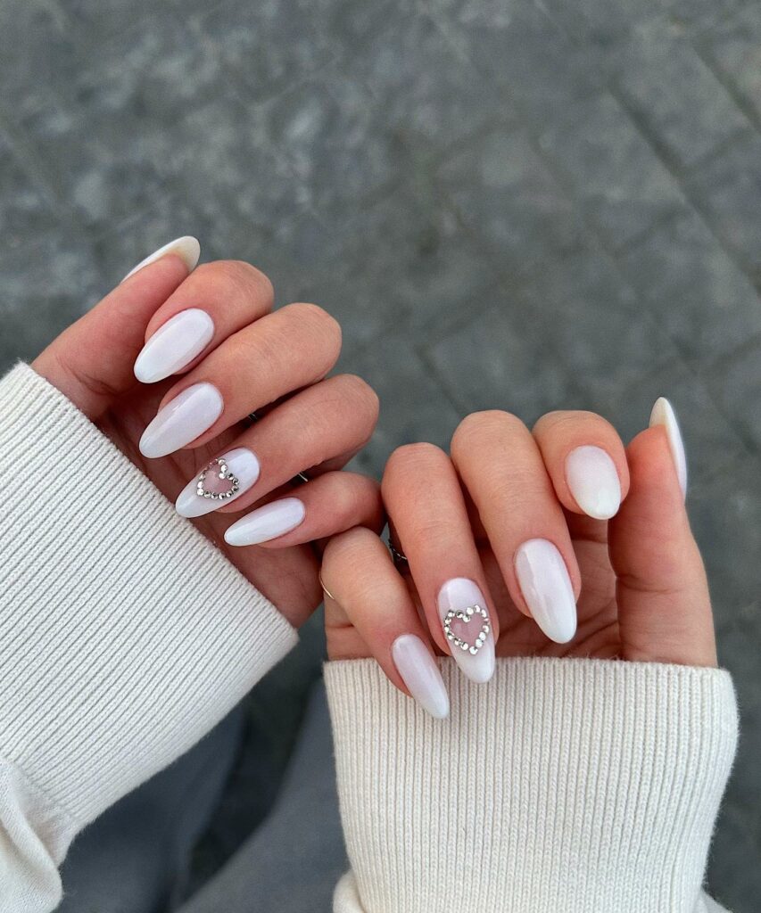 25 Latest Accent Nail Designs To Try In 2024! 21 White Almond With Heart Bedazzled Accent Nails Design