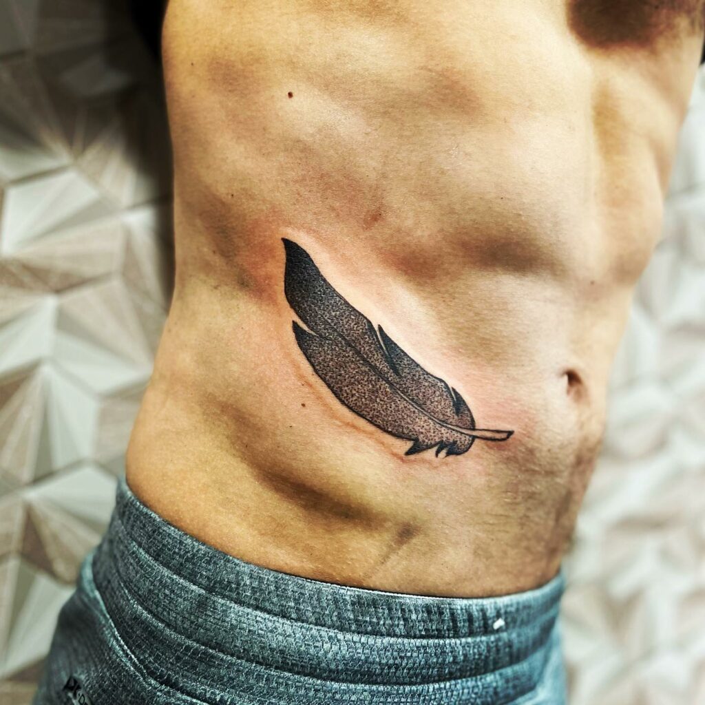 TOP 10 RIB TATTOOS DESIGNS FOR 2024 10 Feather Rib Tattoo