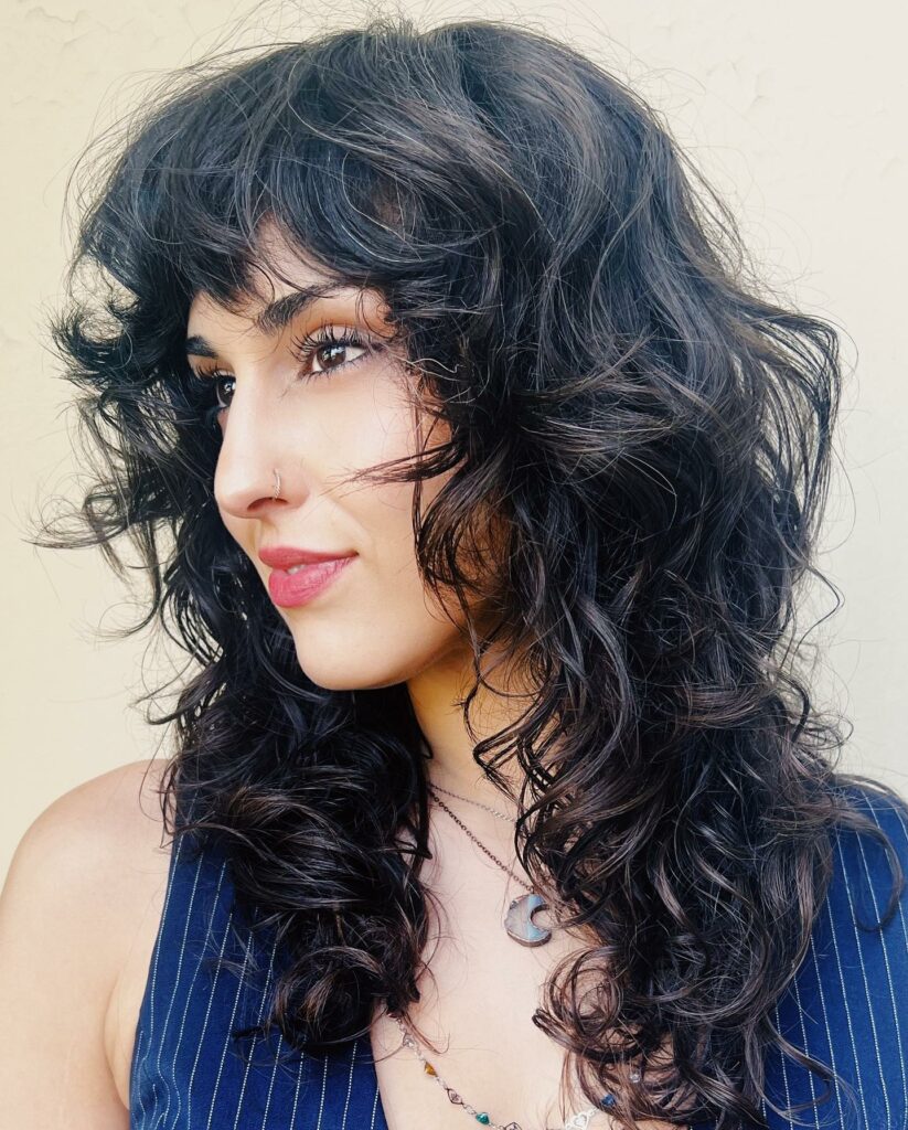 35 Long Wolf Cut Hairstyle Ideas to Try in 2024 14 Curly Wolf Cut With Blunt Bangs