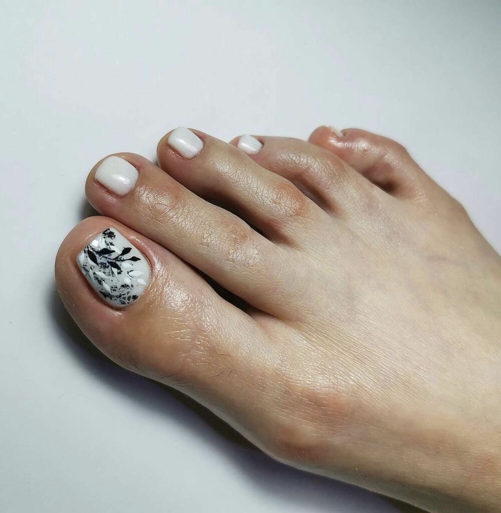 17 Latest Milky White Pedicure Designs To Try In 2024! 22 Milky White Pedicure With Black And White Leaves Design