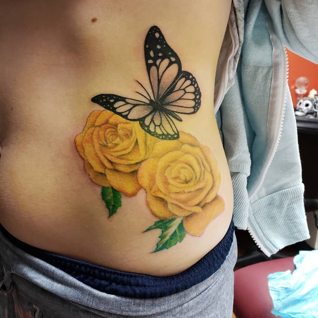 11+ Traditional Tattoo Flowers Ideas That Will Blow Your Mind! 13 Aesthetic Yellow Roses Tattoo With A Monochromatic Butterfly On Top