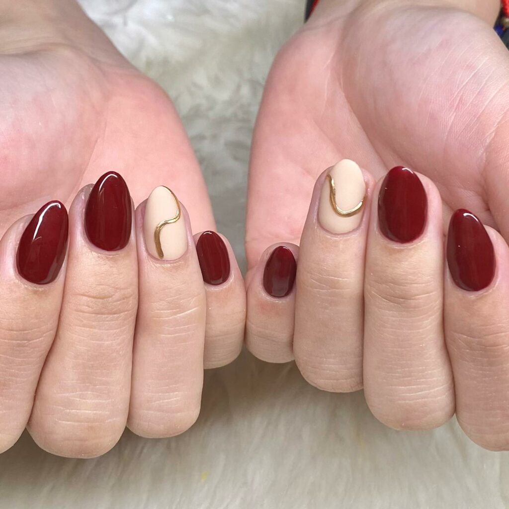 25 Latest Burgundy And Gold Nail Ideas To Try In 2024! 16 Burgundy Nails with Gold Swirl Accents