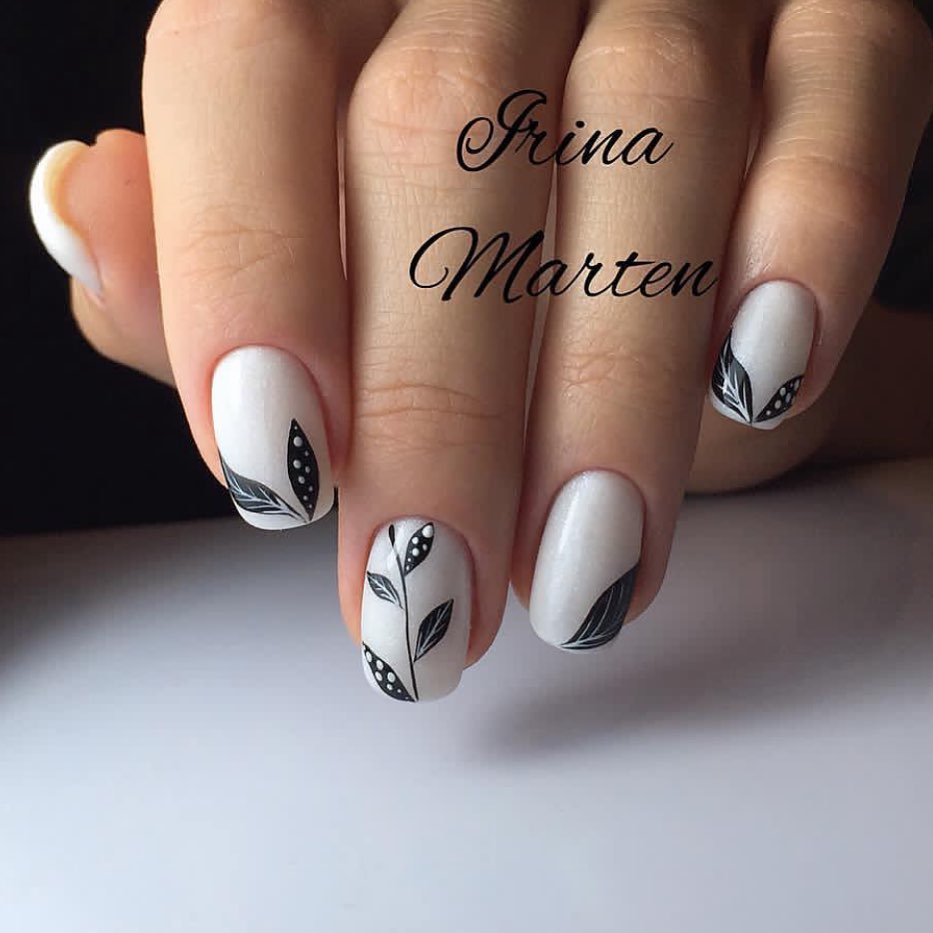 20 Latest Edgy Nail Designs With Drawings to Try In 2024! 34 Chic White Matte with Black Leaf Accents
