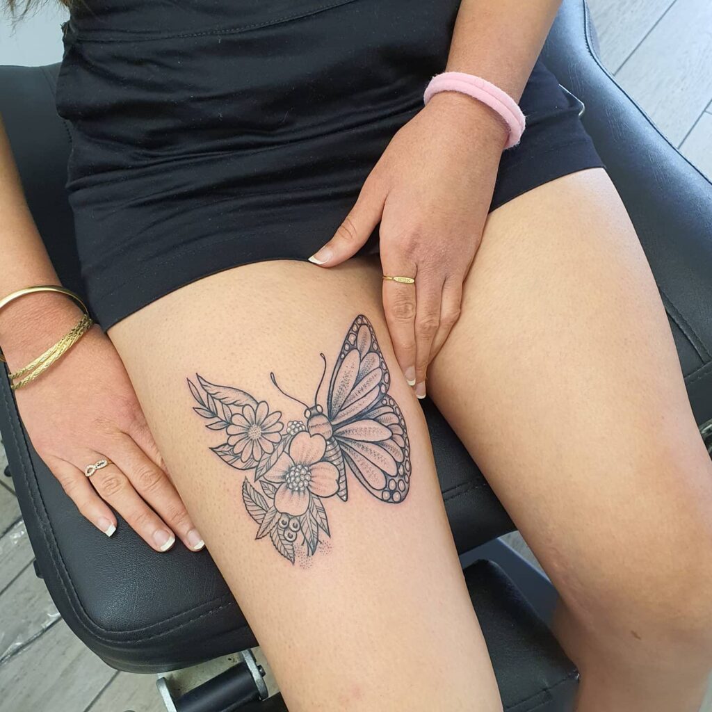 11+ Butterfly Thigh Tattoo Ideas That Will Blow Your Mind! 11 Half Butterfly On Flowers Tattoo