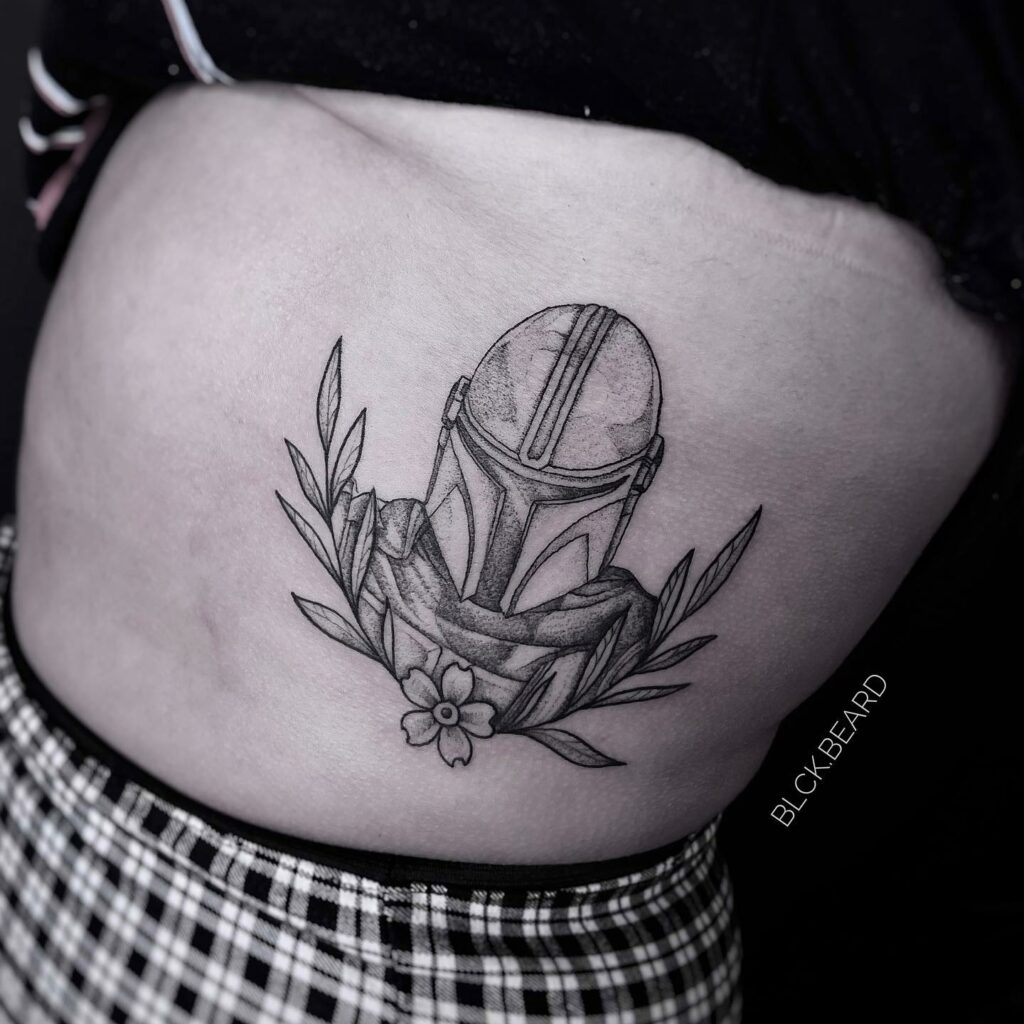 10+ Mandalorian Helmet Tattoo Ideas That Will Blow Your Mind! 14 Mandalorian Helmet With Floral Designs Tattoo