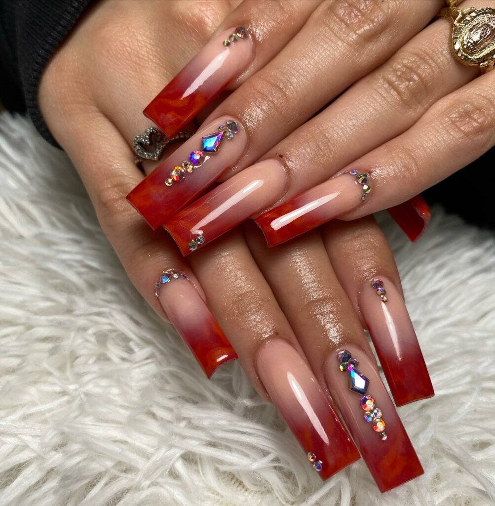 Explore 34 Red Acrylic Nail Designs To Try in 2024 33 Marble Red Acrylic with Gems Nails
