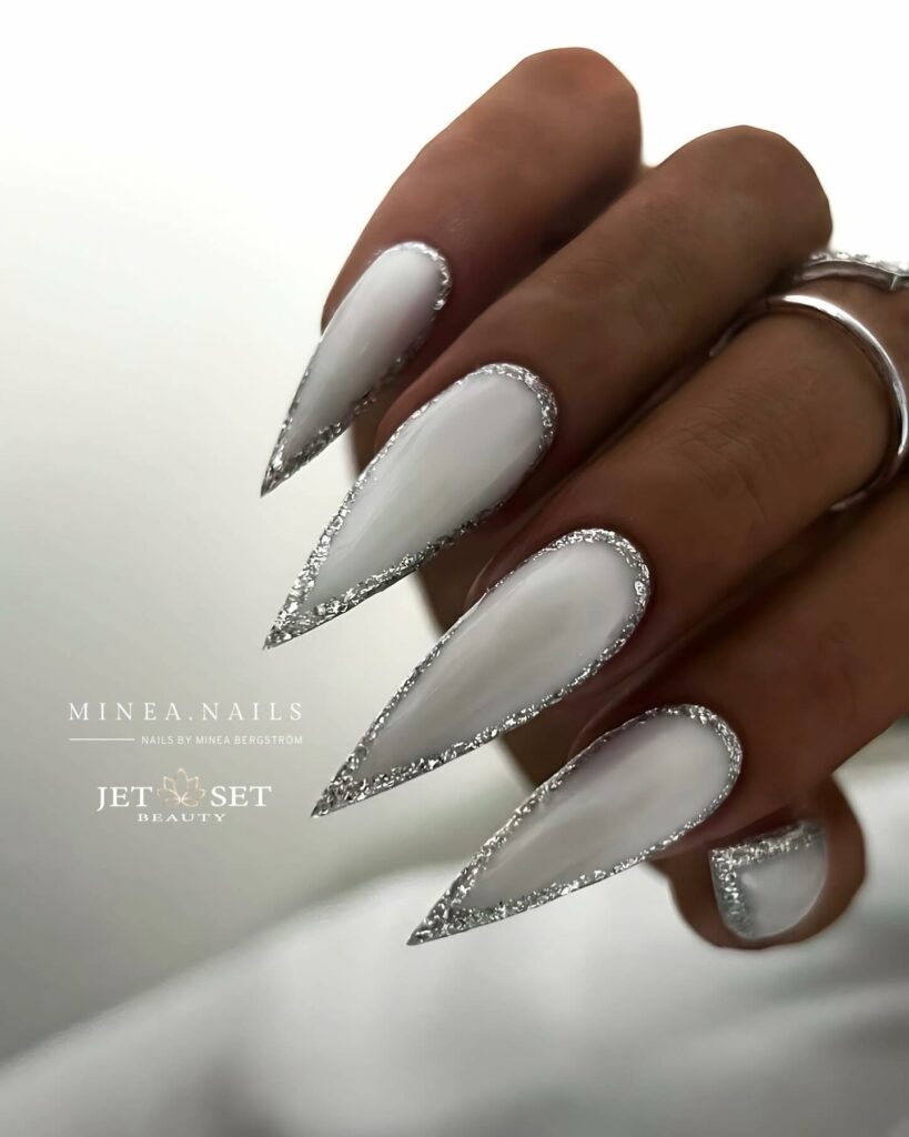 Get Festive with 20 Stiletto Christmas Nail Ideas in 2024 19 Milky White Stiletto Christmas Nails with Glitters